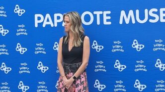 Mujer en el evento "Construye tu ciudad" Papalote Museo del Niño y LEGO. Fondo azul con mariposas y texto "toco juego y aprendo" promoviendo la infancia.