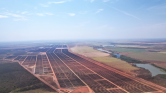 Vista aérea del parque solar de ArcelorMittal en Brasil, mostrando paneles solares extendiéndose hasta el horizonte, reflejando autosuficiencia eléctrica.