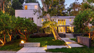 Vista exterior de una casa icónica diseñada por Frank Gehry en Santa Mónica. Arquitectura de lujo con jardines iluminados y diseño único de vanguardia.
