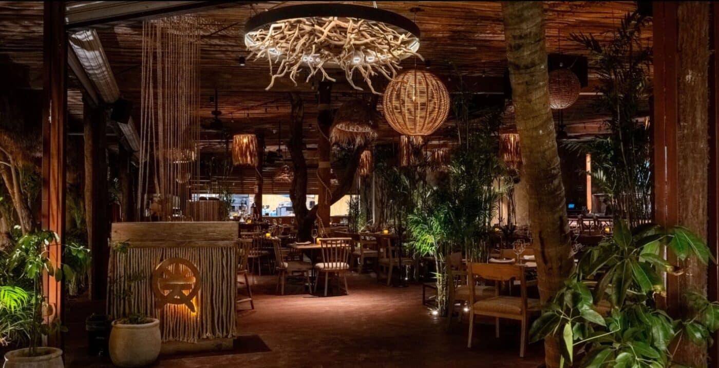 Interior de One Laguna, un restaurante que une la sofisticación y la armonía del Caribe mexicano. Iluminación cálida y decoración con elementos naturales.