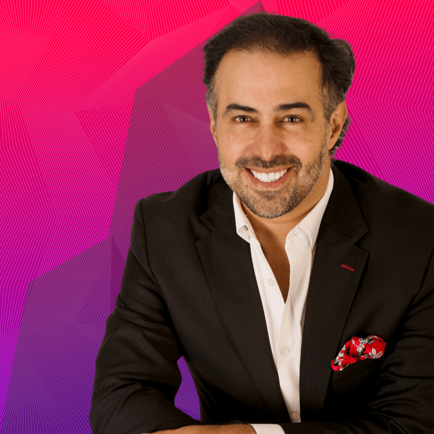 Retrato de un hombre sonriente con traje negro sobre un fondo abstracto rosa y morado. Quienes Somos, destacando su profesionalismo y carisma.