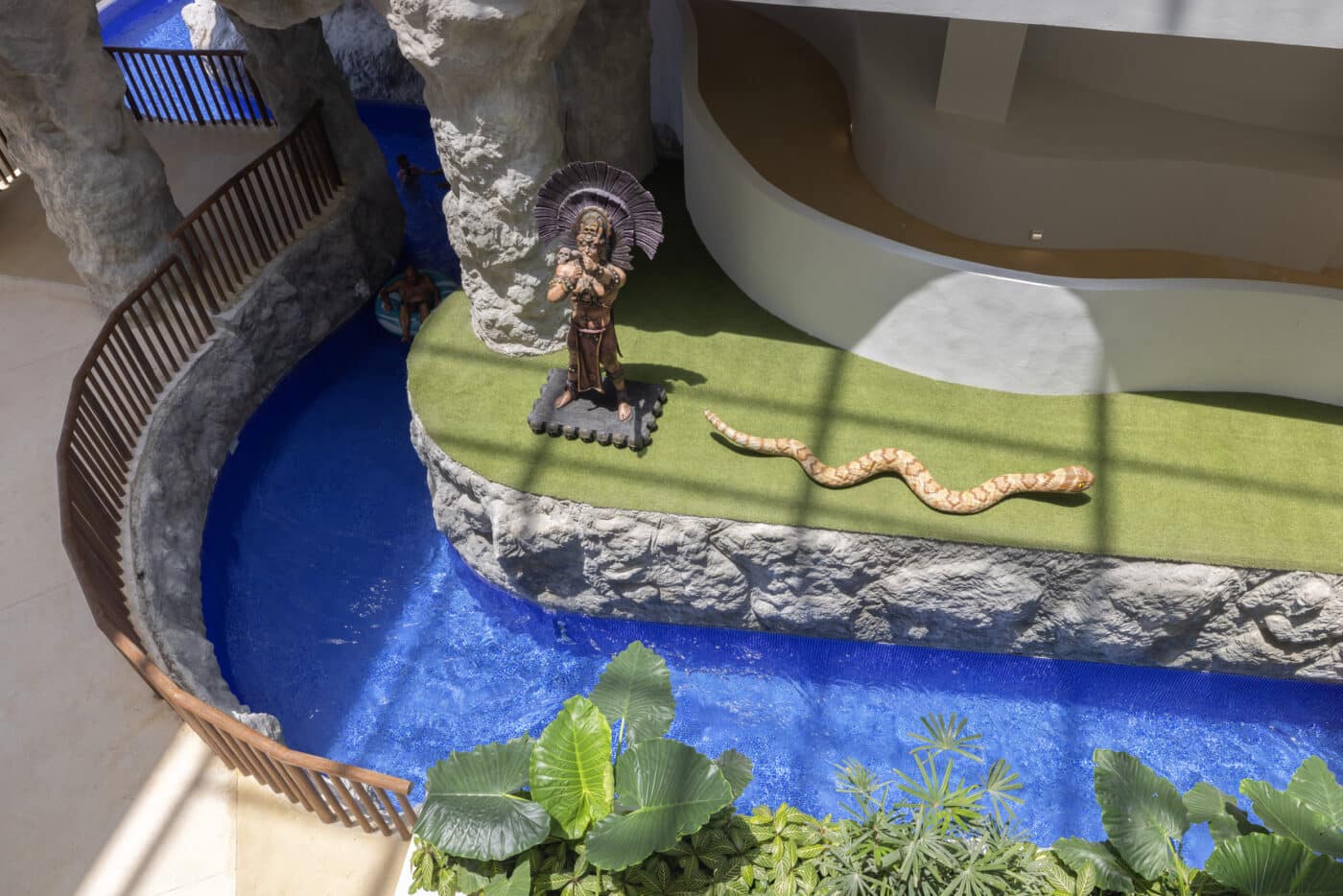 Vista aérea del resort Isla Blanca de Sunset World con un río lento, una estatua maya y una serpiente, promoviendo la realidad virtual en preventa.