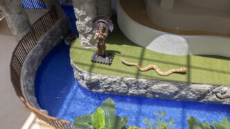 Vista aérea del resort Isla Blanca de Sunset World con un río lento, una estatua maya y una serpiente, promoviendo la realidad virtual en preventa.