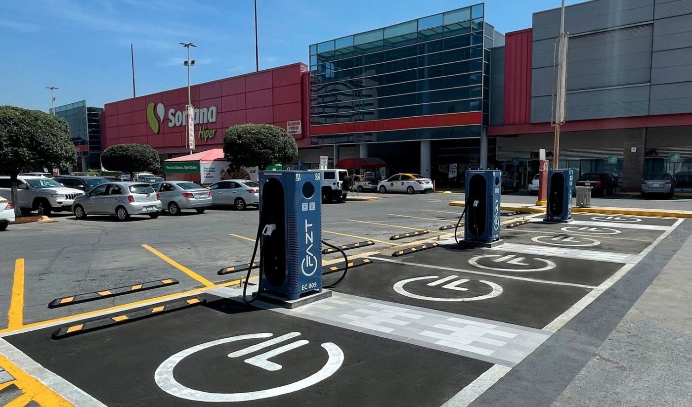 Estaciones FAZT Charging XCharge para vehículos eléctricos en México. Puntos de carga modernos en estacionamiento exterior con autos y tienda.
