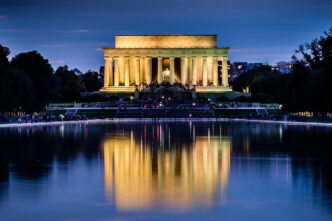 El Monumento a Lincoln iluminado se refleja en el agua frente al estanque Reflectante en Washington D.C.