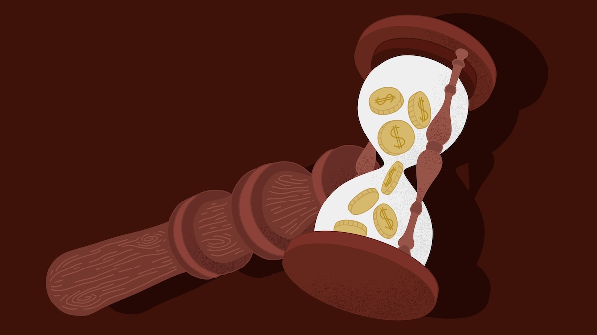 Persona coloca un mazo de madera junto a un reloj de arena con monedas visibles.