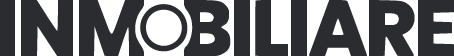 Persona leyendo INMOBILIARE en letras mayúsculas negras sobre fondo gris.