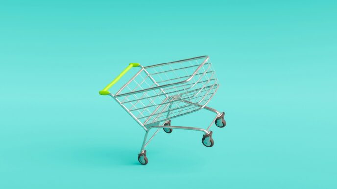 Carrito de metal con asa amarilla vacío sobre fondo turquesa con texto tendencias de retail innovation.