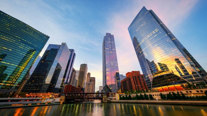 Rascacielos de vidrio reflejan la luz del atardecer junto a un río y el logo de Barnes & Noble en Chicago.