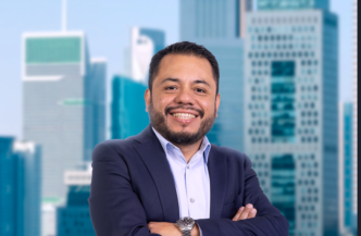 Persona de traje con brazos cruzados frente a oficinas modernas en el evento IMEI BOMA 2027.