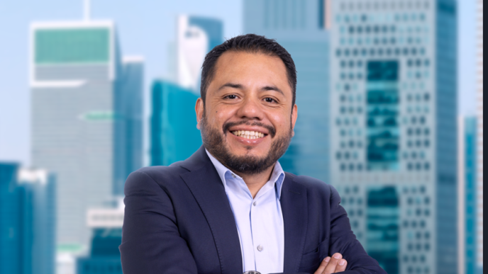 Persona de traje con brazos cruzados frente a oficinas modernas en el evento IMEI BOMA 2027.